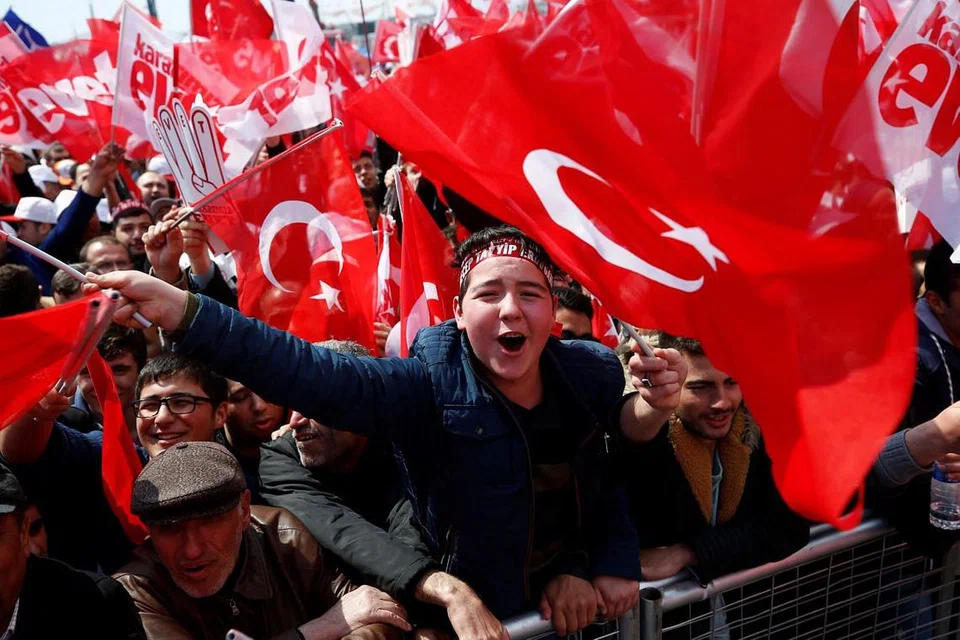 RAI KEMENANGAN: Penyokong Presiden Tayyip Erdogan mengibarkan bendera Turkey semasa perhimpunan yang diadakan di Istanbul pada 8 April lalu. Golongan penyokong meraih 51.4 peratus undi mengatasi golongan penentang yang mendapat 48.6 peratus undi. - Foto REUTERS
