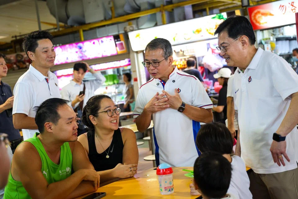 Menteri Kebudayaan, Masyarakat dan Belia, Encik Edwin Tong (berdiri, dua dari kanan), berinteraksi dengan penduduk ketika melawat beberapa kedai kopi di Marine Parade. Di kirinya ialah Timbalan Perdana Menteri, Encik Heng Swee Keat. 