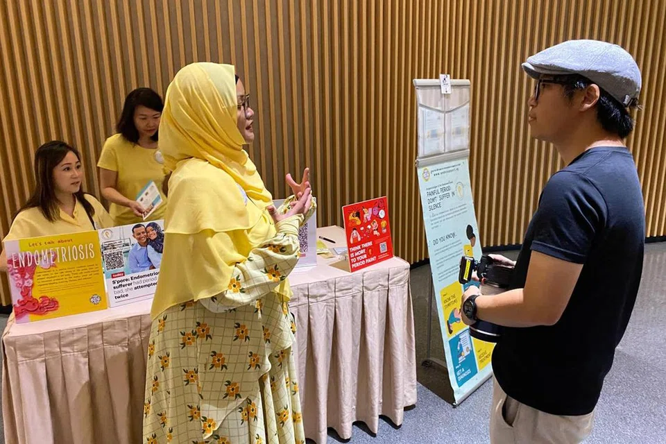 Pengasas E for Endometriosis, Cik Namira Mohamad Marsudi, yang juga penerima Anugerah Heroin SG 24 di Festival Wanita SG (bertudung kuning) memberi penerangan kepada salah seorang hadirin semasa acara, ‘Wear Yellow SG EndoMarch 2024’.