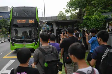 Para peminat bas mengambil foto perkhidmatan bas 861 sedang ia menghampiri tempat perhentian bas di luar stesen MRT Khatib pada 15 September - hari pertama perkhidmatan itu bermula. 