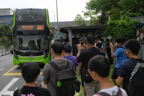Para peminat bas mengambil foto perkhidmatan bas 861 sedang ia menghampiri tempat perhentian bas di luar stesen MRT Khatib pada 15 September - hari pertama perkhidmatan itu bermula. 