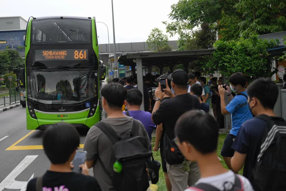 Para peminat bas mengambil foto perkhidmatan bas 861 sedang ia menghampiri tempat perhentian bas di luar stesen MRT Khatib pada 15 September - hari pertama perkhidmatan itu bermula. 