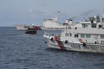 TINDAKAN AGRESIF: Dua kapal pengawal pantai China dilihat sedang memantau bot awam yang disewa tentera laut Filipina untuk menghantar bekalan kepada kapal tentera laut Filipina BRP Sierra Madre di Laut China Selatan pada 22 Ogos. 