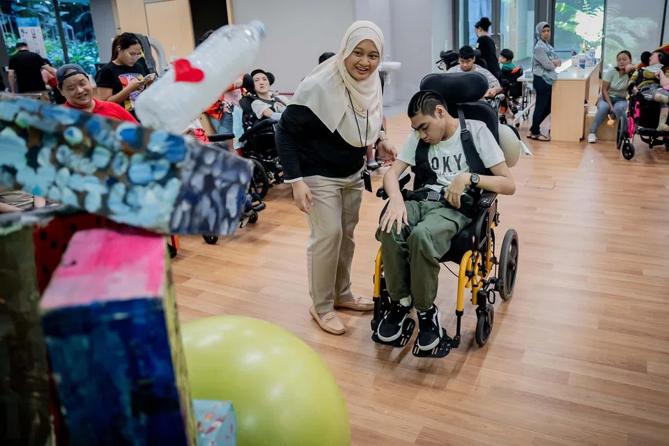 Cik Nur Atiqah Hairodin sedang mengendalikan kegiatan bersama golongan kurang upaya yang dihantar ke pusat tersebut untuk menyertai program kendalian AWWA.
