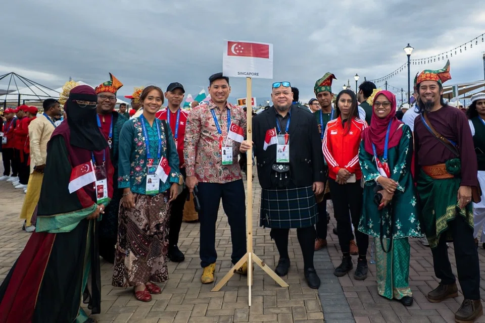 Encik Sufi (kanan), Cik Zayanah (dua dari kanan) dan Encik Taufiq (depan, empat dari kanan) bersama atlet Singapura yang lain dalam temasya sukan dwitahunan tersebut.