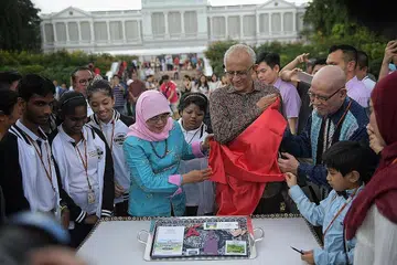 LANCAR MEMORABILIA BARU: Bagi menunjukkan sokongan beliau terhadap golongan berkepeluan khas, Presiden Halimah Yacob (tengah), yang ditemani suaminya, Encik Mohamed Abdullah Alhabshee, melancarkan Memorabilia Cabaran Presiden sewaktu Rumah Terbuka Tahun Baru Cina semalam. - Foto BM oleh ARIFFIN JAMAR