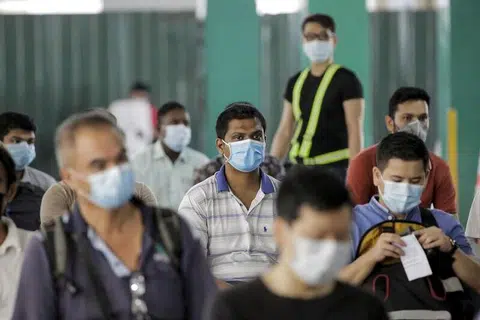 PASARAN BURUH: Pekerja penting menunggu di pusat pemeriksaan untuk menjalani ujian swab Covid-19 di The Float @ Marina Bay di Singapura, pada 10 Jun lalu.