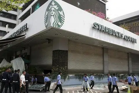 BERSIHKAN KAWASAN: Pekerja membersihkan sekitar kawasan restoran Starbucks Coffee dekat tempat serangan militan yang membunuh tujuh orang termasuk lima anggota militan. - Foto REUTERS
