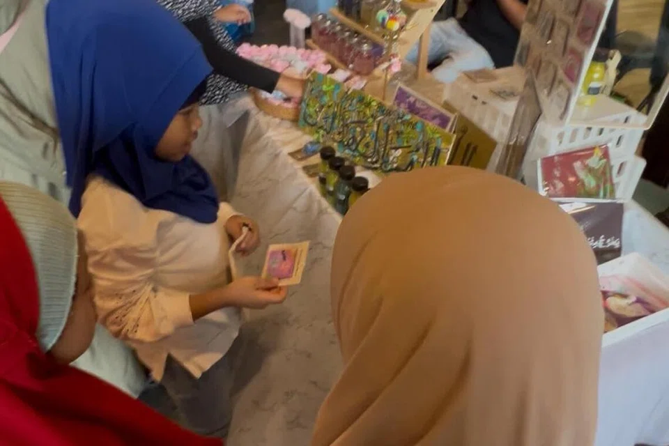 Nur Iman Ilyana Muhammad Imran, enam tahun, (bertudung biru) menjual rantai kunci, sabun dan lilin jeli yang dibuat sendiri di reruai yang dikendali bersama saudaranya, Nur Adawiyah Ruqayyah Muhammad Syafiq, tujuh tahun, (bertudung hitam).