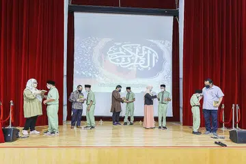 TERIMA MUSHAF: Pelajar Menengah Satu Itqan menerima mushaf dari waris masing-masing di program Induksi Menengah 1 pada 8 Januari lalu. Dari kiri ialah Adam Omar, Adam Fawzan Rachmat, Ahmad Iskandar Al-Harith Muhammad Faizal, Ali Muhsin Shahril dan Handzolah Muhammad Taufiq. - Foto MAI