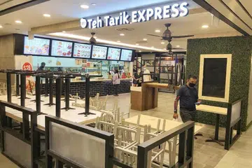 FASA KEDUA MULAI ESOK: Seorang lelaki memakai pelitup berjalan keluar dari restoran Teh Tarik EXPRESS di bangunan SingPost pada 15 Jun lalu. Singapura mula melonggarkan sekatan pergerakan yang dikenali sebagai tempoh pemutus rantaian jangkitan esok, yang akan membolehkan tidak lebih lima orang duduk semeja di restoran atau kedai kopi atau di pusat makan.