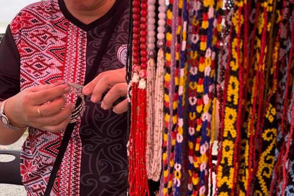KREATIF DAN CANTIK: Seorang peniaga asal Sarawak menjual cenderahati yang diperbuat daripada manik, iaitu antara produk unik dari Bumi Kenyalang, di Pasar Borneo.