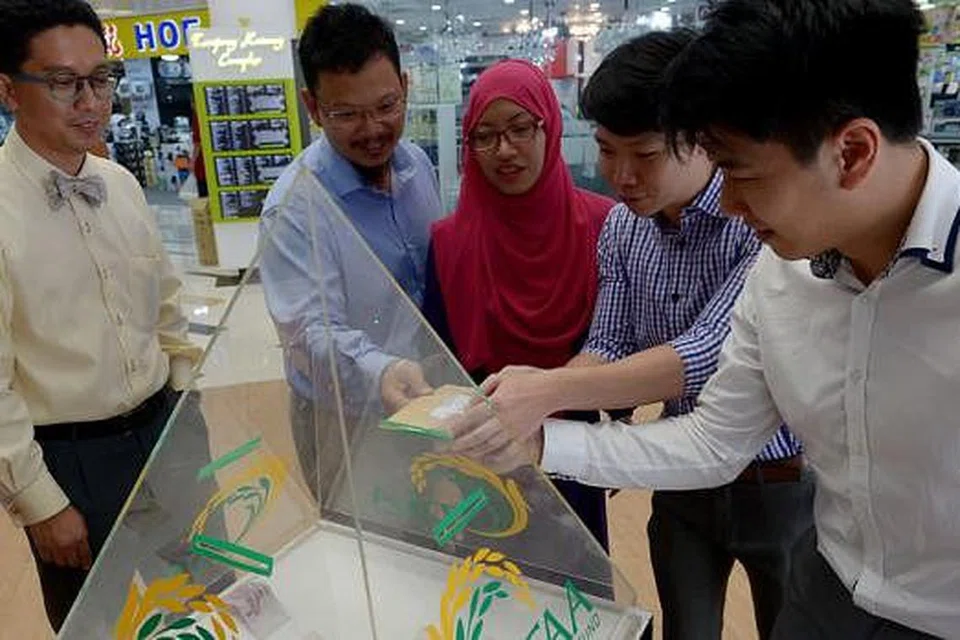 MENDERMA BAGI MEMBANTU MEREKA YANG LEBIH MEMERLUKAN: (Dari kiri) Dr Abdul Razakjr Omar, Dr Zuraimi Dahlan, Dr Elly Sabrina Ismail, Timothy Goh dan Jonathan Mun, mendermakan kepada tabung TAA wang sebanyak $820 yang dikumpul di gerai pendaftaran di bazar Ramadan Geylang Serai. - Foto TUKIMAN WARJI