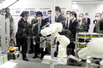 SISTEM CANGGIH: Menteri Kesihatan Jepun, Norihisa Tamura menyaksikan satu demonstrasi prototaip mesin ujian Covid-19 automatik yang menggunakan robot untuk mengambil sampel ujian swab. - Foto Reuters