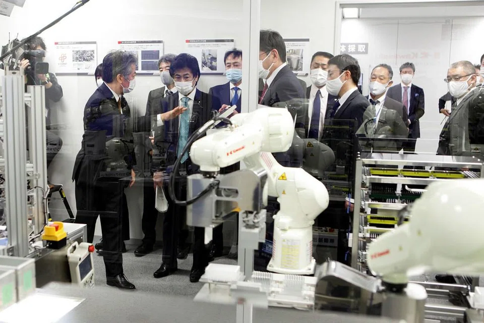 SISTEM CANGGIH: Menteri Kesihatan Jepun, Norihisa Tamura menyaksikan satu demonstrasi prototaip mesin ujian Covid-19 automatik yang menggunakan robot untuk mengambil sampel ujian swab. - Foto Reuters