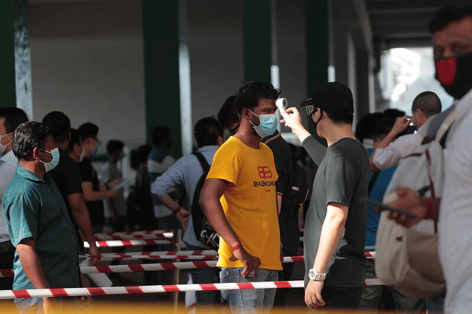 PERIKSA SUHU: Pekerja sektor penting menjalani pemeriksaan sebelum memasuki The Float@Marina Bay. 