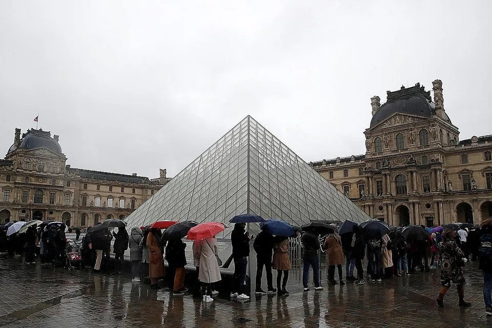 KAKITANGAN ENGGAN KERJA: Pengunjung ke Muzium Louvre beratur di luar bangunan tatkala muzium itu ditutup kepada ramai semasa ia mengadakan mesyuarat bersama kakitangan berhubung penularan koronavirus di Paris pada hujung minggu lalu. - REUTERS