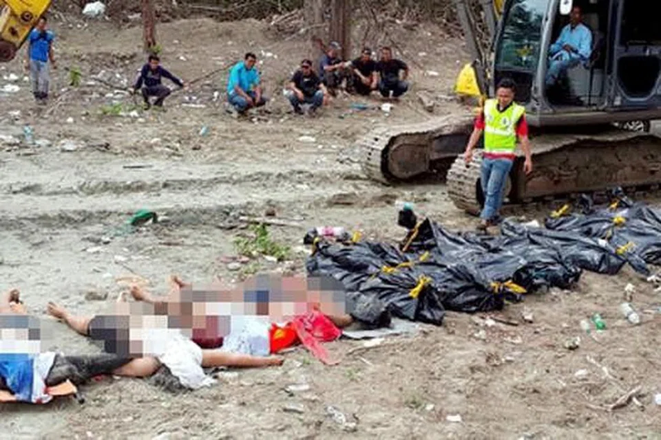 MAYAT DIPERIKSA: Anggota polis memeriksa mayat seramai 13 pendatang asing tanpa izin dipercayai warga Indonesia yang lemas dalam kejadian bot karam di perairan Tanjung Balau, Kota Tinggi, malam kelmarin. - Foto NSTP