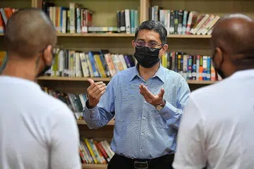 PENDIDIKAN DEMI PEMULIHAN: Profesor Madya Muhammad Faishal Ibrahim beramah-tamah bersama beberapa tahanan yang menerima keputusan peperiksaan GCE peringkat 'O' mereka minggu lalu di perpustakaan Institusi Tanah Merah 1. - Foto BH oleh CHONG JUN LIANG