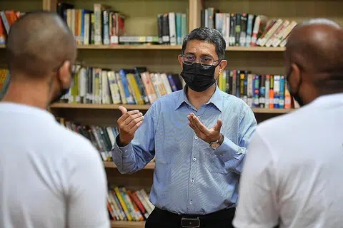 PENDIDIKAN DEMI PEMULIHAN: Profesor Madya Muhammad Faishal Ibrahim beramah-tamah bersama beberapa tahanan yang menerima keputusan peperiksaan GCE peringkat 'O' mereka minggu lalu di perpustakaan Institusi Tanah Merah 1. - Foto BH oleh CHONG JUN LIANG