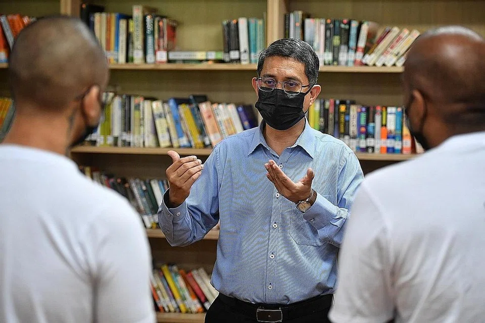 PENDIDIKAN DEMI PEMULIHAN: Profesor Madya Muhammad Faishal Ibrahim beramah-tamah bersama beberapa tahanan yang menerima keputusan peperiksaan GCE peringkat 'O' mereka minggu lalu di perpustakaan Institusi Tanah Merah 1. - Foto BH oleh CHONG JUN LIANG