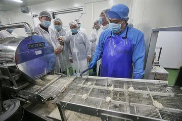 KEMUDAHAN BARU: Encik Chee Hong Tat (paling kiri) meninjau kemudahan yang dimanfaat syarikat Tenderfresh Fried & BBQ Chicken di Hab Makanan JTC@Senoko. - Foto ZAOBAO.