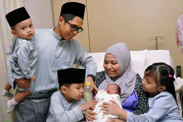 KELAHIRAN CAHAYA MATA SYAWAL: Cik Siti Zalinah Adam menimang cahaya mata yang baru dilahirkannya, Safwa Aisyah. Bersama beliau ialah (dari kiri) Syahmi Ilham, Encik Mohd Fazlan Abdul Samat, Shouqi Haqqi dan Shaura Marissa. - Foto KHALID BABA