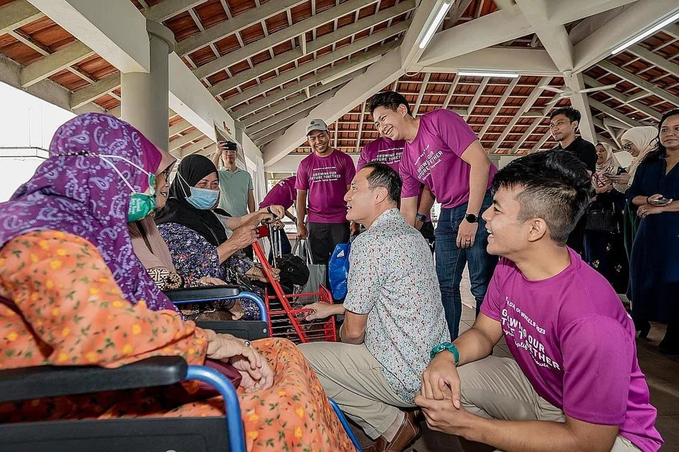 SEBAR KECERIAAN: Encik Tan Kiat How (dua dari kanan), yang didampingi Encik Danish Hisham (sebelah kirinya), dan Presiden 4PM, Encik Nassar Mohamad Zain (sebelah kanannya), berinteraksi dengan penerima bantuan di daerah pejabat 4PM di 606 Bedok Reservoir Road. - Foto BH oleh NUR DIYANA TAHA