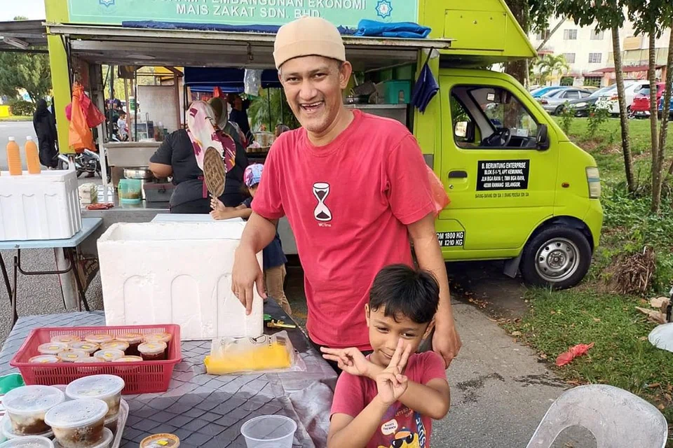 RAYA SERBA SEDERHANA: Peniaga Encik Mohd Noor Mohd Khir dan anaknya, Adam, akan menyambut Raya dengan penuh kesederhanaan. Kenaikan kos sara hidup menjejas peniaga seperti beliau. - Foto BH oleh KHIRUL BAHRI BASARUDDIN