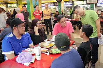 DEKATI MASYARAKAT: Encik Chan (berbaju merah jambu) dan Encik Lee (kanan) telah berjalan-jalan untuk bertemu penduduk di kawasan Jurong Spring sewaktu Lawatan Masyarakat Menteri semalam. - Foto BH oleh GIN TAY