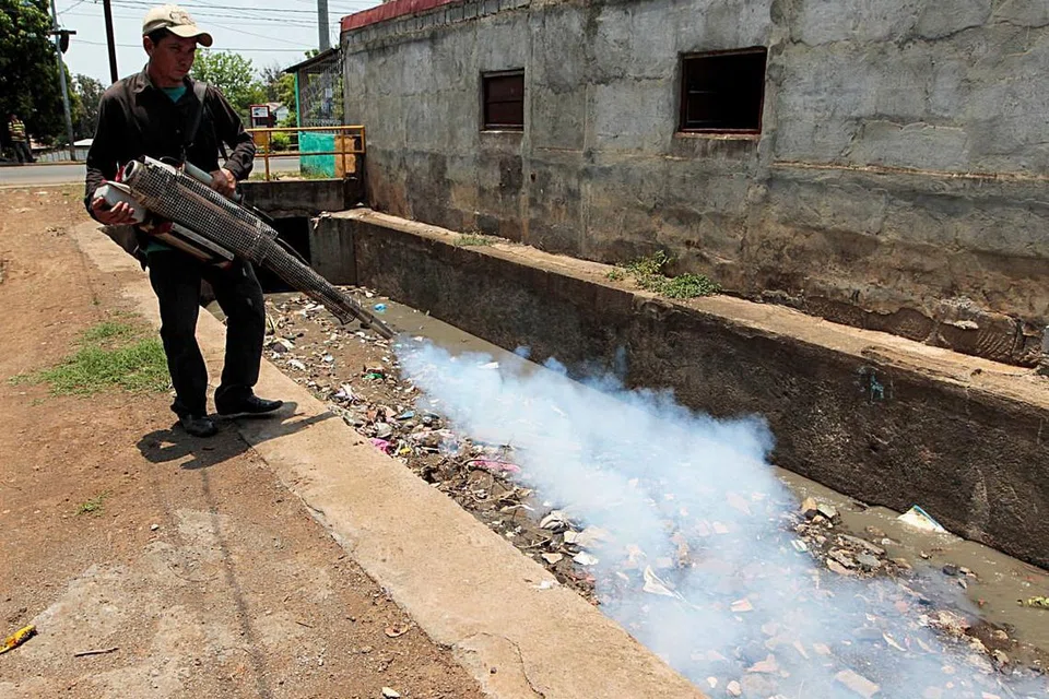 Seorang pekerja kesihatan mewasap di luar rumah di sebuah kawasan kejiranan selepas pemerintah Nicaragua mengisytiharkan amaran epidemiologi kerana peningkatan kes demam denggi dan Zika di ibu negara Managua pada 9 Mei 2016. 