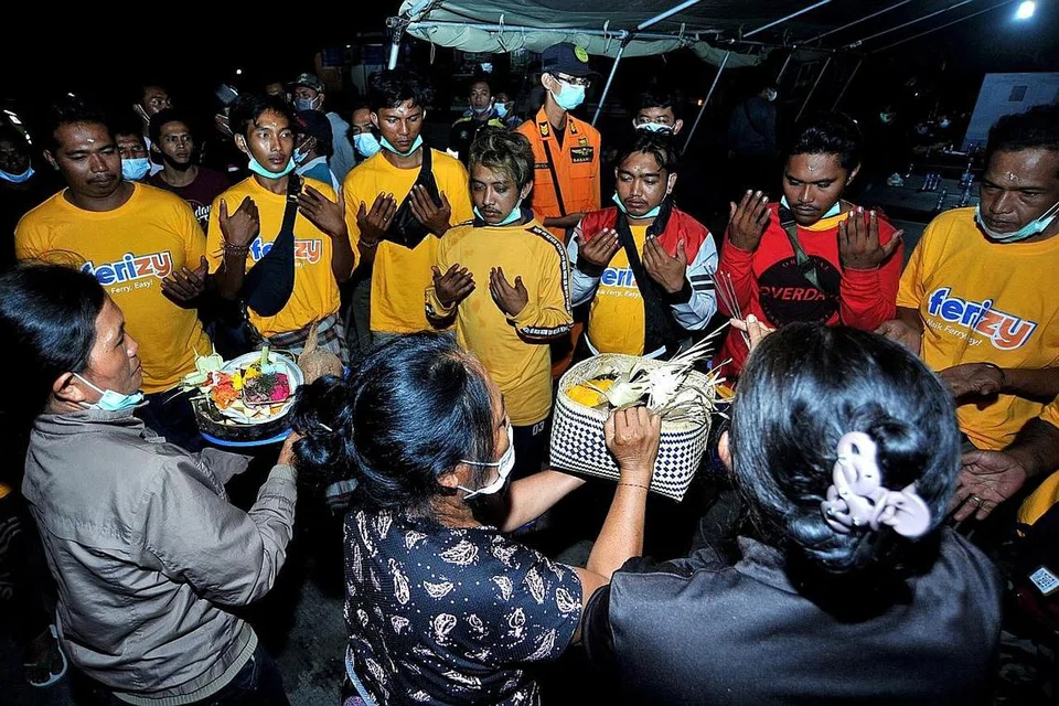 MUJUR SELAMAT: Penumpang feri KMP Yunice yang terselamat, dilihat membaca doa dan melakukan upacara keagamaan selepas mereka tiba di pelabuhan Gilimanuk di Bali. - Foto REUTERS 