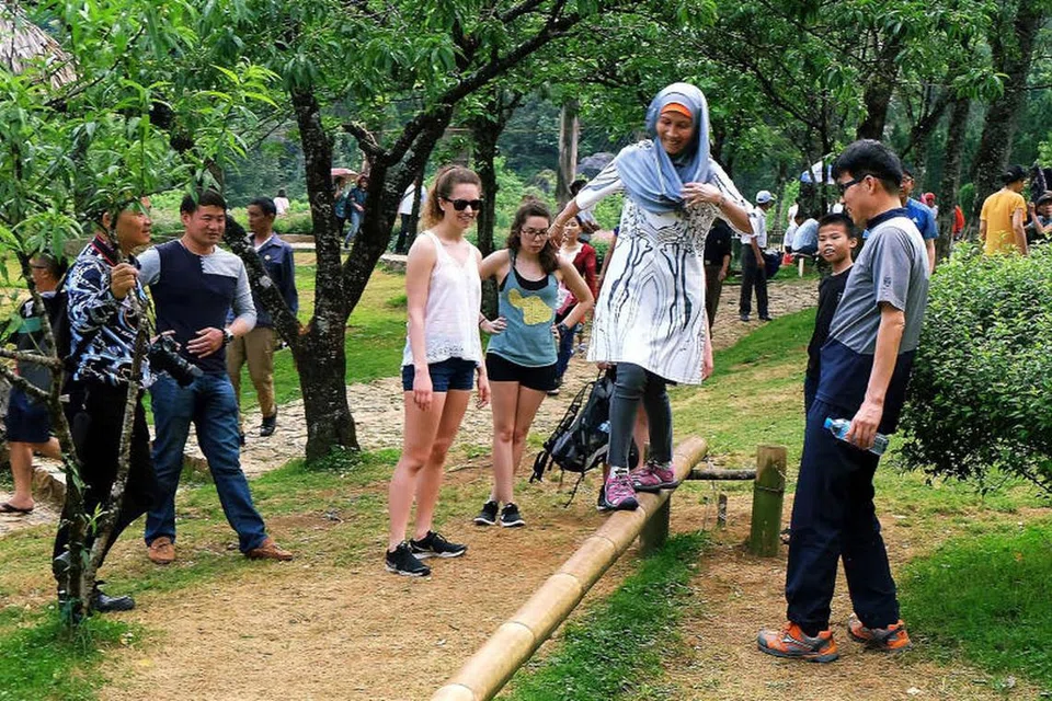 BERSANTAI SETELAH PENAT BERJALAN: Isteri jurugambar Khalid Baba, Cik Zailina Mohd Zain (bertudung) dan beberapa pelancong bergembira seketika di tempat persinggahan sebelum sambung berjalan untuk mendaki Gunung Ham Rong.