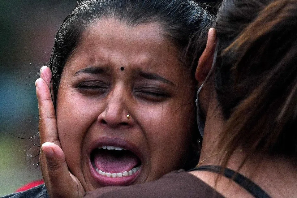 PILU KEHILANGAN: Seorang wanita meraung sambil didakap bagi menenangkannya menyusuli nahas yang meragut nyawa seramai 22 orang kelmarin. - Foto AFP 