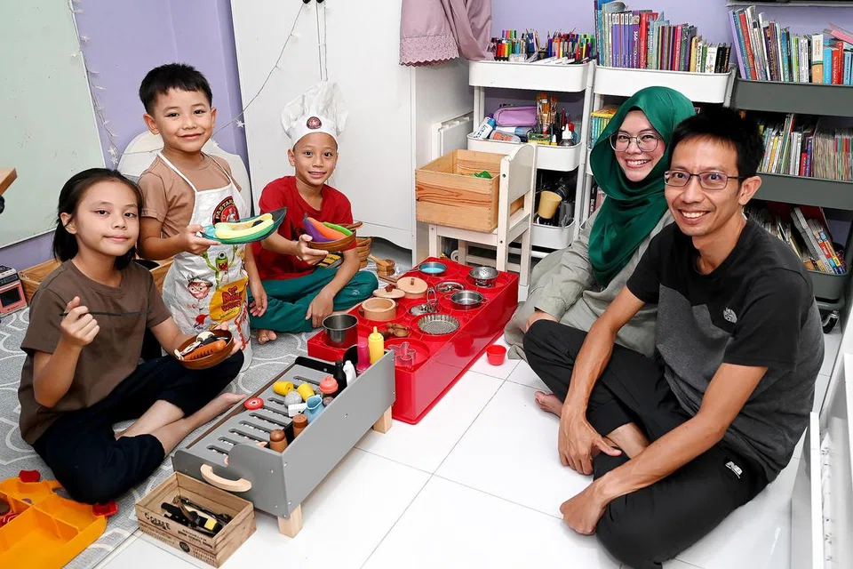 Cik Siti Saliha Ismail dan Encik Husaini Jaafar memberi anak-anak mereka (dari kiri) Qairina, Qawiem dan Qa’id masa bermain selepas sekolah setiap hari. 