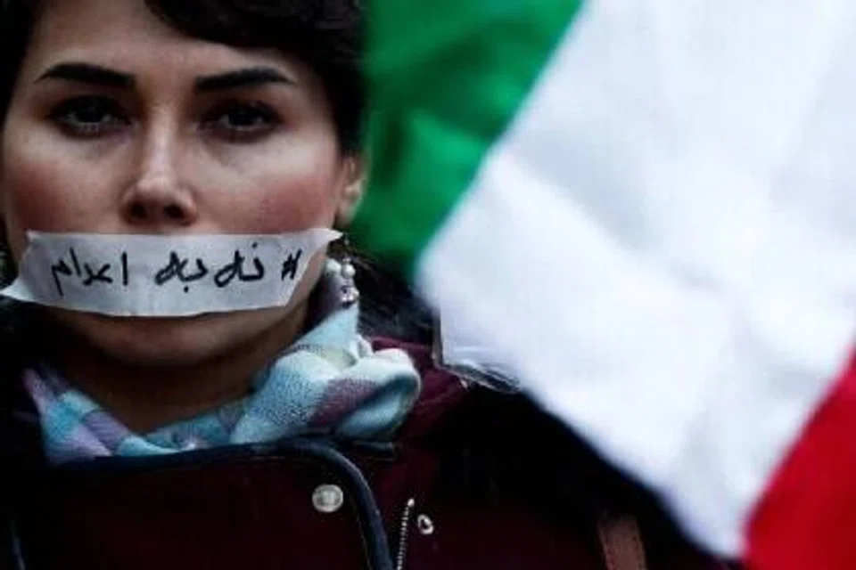 Penunjuk perasaan dengan pelekat “tiada hukuman mati” pada mulutnya menyertai perarakan senyap di Paris, pada 31 Januari, bagi mengecam tindakan keras pemerintah Iran terhadap penunjuk perasaan di negara itu.