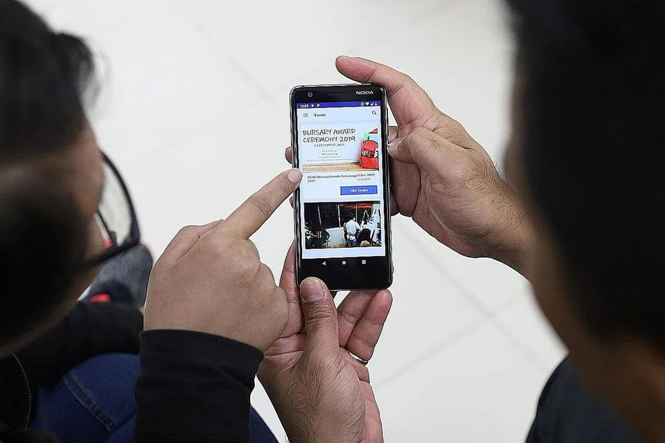 MANFAAT APLIKASI: Cik Mirah (kiri) menunjuk ajar Encik Rahman kandungan yang terdapat dalam aplikasi baru Iscos termasuk acara dan inisiatif, pendaftaran untuk acara serta membuat temu janji bagi dapatkan bantuan persatuan itu. - Foto BH oleh MARCELLIN LOPEZ