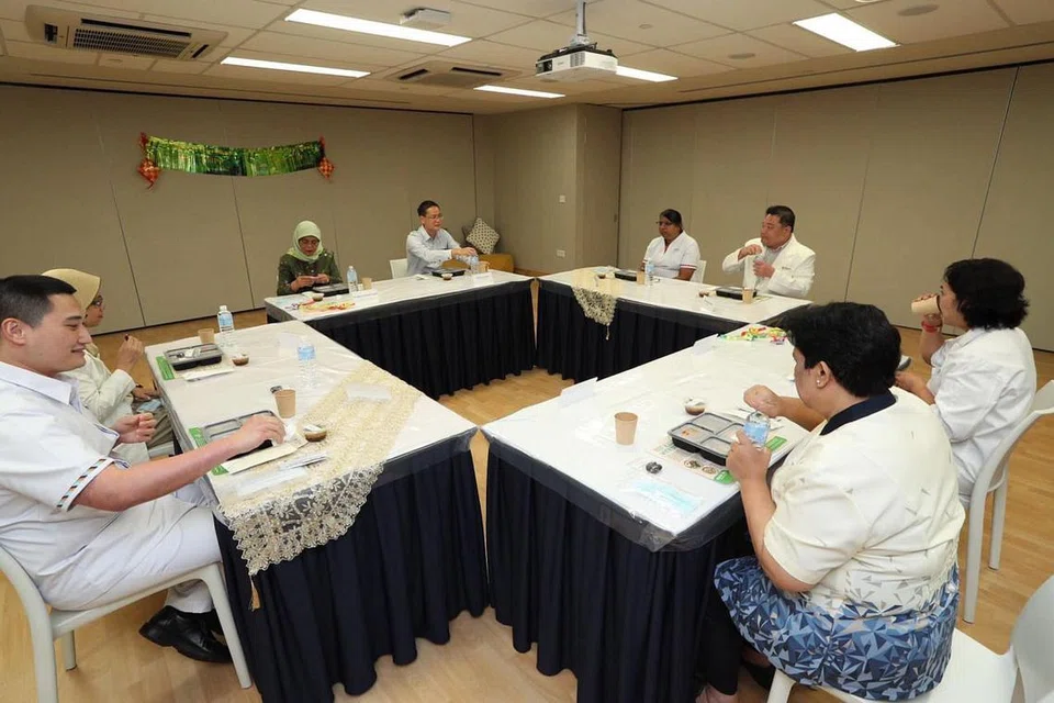 BUKA PUASA BERSAMA: Presiden Halimah Yacob (tiga dari kiri) berbuka puasa bersama beberapa pekerja barisan hadapan di Hospital Besar Changi (CGH). - Foto MCI OLEH ZINKIE AW