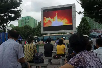 UJIAN TERKINI: Rakyat Korea Utara menonton siaran pelancaran peluru berpandu balisitk antara benua (ICBM) terkini yang ditayangkan pada skrin di tempat awam di Pyongyang semalam. Pemimpin Korea Utara, Encik Kim Jong-un, mendabik dada menyatakan bahawa ICBM itu boleh menjangkau semua bandar utama di Amerika Syarikat. - Foto AFP