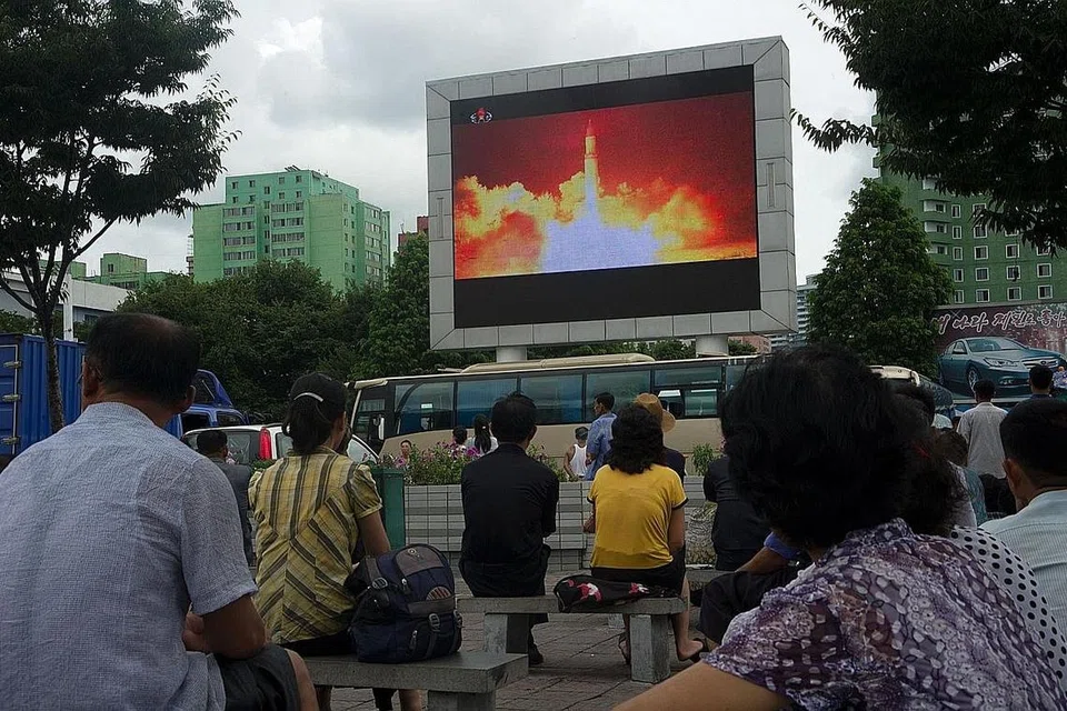 UJIAN TERKINI: Rakyat Korea Utara menonton siaran pelancaran peluru berpandu balisitk antara benua (ICBM) terkini yang ditayangkan pada skrin di tempat awam di Pyongyang semalam. Pemimpin Korea Utara, Encik Kim Jong-un, mendabik dada menyatakan bahawa ICBM itu boleh menjangkau semua bandar utama di Amerika Syarikat. - Foto AFP