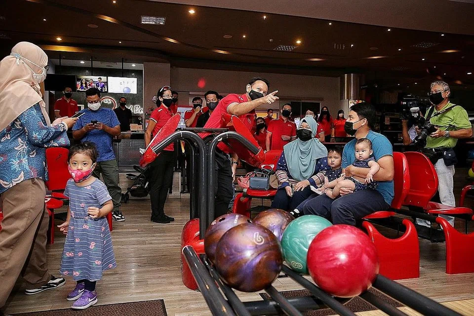 SKIM BAGI KELUARGA: Encik Zaqy dilihat sedang berbual bersama keluarga di Orchid Bowl semasa lawatannya ke Safra Yishun semalam di mana beliau mengumumkan skim pakej baru bagi keluarga anggota Safra dan HomeTeamNS. - Foto BM oleh KEVIN LIM