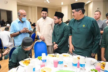 Menteri Ehwal Dalam Negeri merangkap Undang-Undang, Encik K. Shanmugam (kiri) dan Pengerusi Masjid Khalid, Dr Mohamed Ariffin Mohamed Kawaja Kamaludin (dua dari kiri), beramah mesra dengan anggota kariah sewaktu menghadiri majlis berbuka puasa bagi menghargai kumpulan kariah di auditorium Masjid Khalid pada 6 Mac.