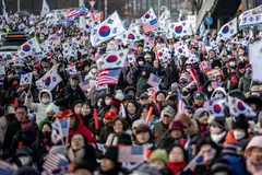 Penyokong Presiden Korea Selatan yang digantung tugas, Encik Yoon Suk Yeol, mengibarkan bendera Amerika dan Korea Selatan dekat kediaman Presiden di Seoul pada 1 Januari.