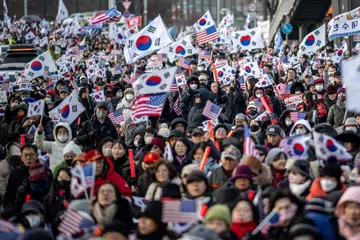 Penyokong Presiden Korea Selatan yang digantung tugas, Encik Yoon Suk Yeol, mengibarkan bendera Amerika dan Korea Selatan dekat kediaman Presiden di Seoul pada 1 Januari.