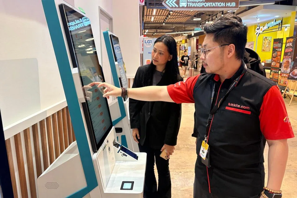 Ketua Pegawai Eksekutif ttklia.com, syarikat yang mengendalikan LaLaPort Transportation Hub, di Bukit Bintang City Centre, Kuala Lumpur, Encik Aaron Chuah (kanan), menunjukkan kemudahan kiosk pembelian tiket bas layan diri.