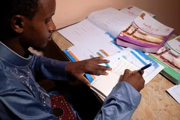 DI MANA ADA KEMAHUAN DI SITU ADA JALAN: Mamadou Safaiou Barry sedang berlatih menulis bahasa Arab di rumah barunya di daerah El Marg di timur Kahirah di Mesir. Beliau tiba di Kahirah setelah mengayuh basikal selama empat bulan merentasi tujuh negara.