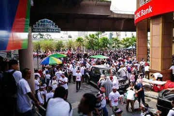 SERTAI BANTAHAN: Orang ramai berhimpun di bawah landasan LRT di Masjid Jamek.