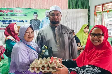 Pengarah IbadahSg Pte Ltd, Ustaz Firdaus Masruhen (tengah), menyaksikan agihan makanan asas kepada ibu tunggal (kiri) oleh ketua yayasan mualaf (kanan) di pesantren di Bali pada Februari. Acara itu adalah untuk memberi makanan asas kepada ibu tunggal dan mualaf di Bali, Indonesia.