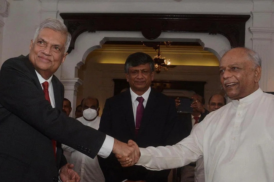 MAJLIS PELANTIKAN: Encik Dinesh Gunawardena (kanan), yang dilantik sebagai PM baru Sri Lanka, berjabat tangan dengan presiden baru, Encik Ranil Wickremesinghe. - Foto REUTERS