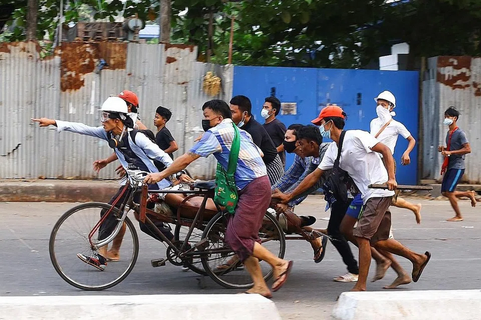 CUBA DISELAMATKAN: Beberapa orang sedang membawa pergi seorang penunjuk perasaan yang ditembak oleh pihak keselamatan Myanmar dalam satu bantahan di Yangon kelmarin. - Foto REUTERS